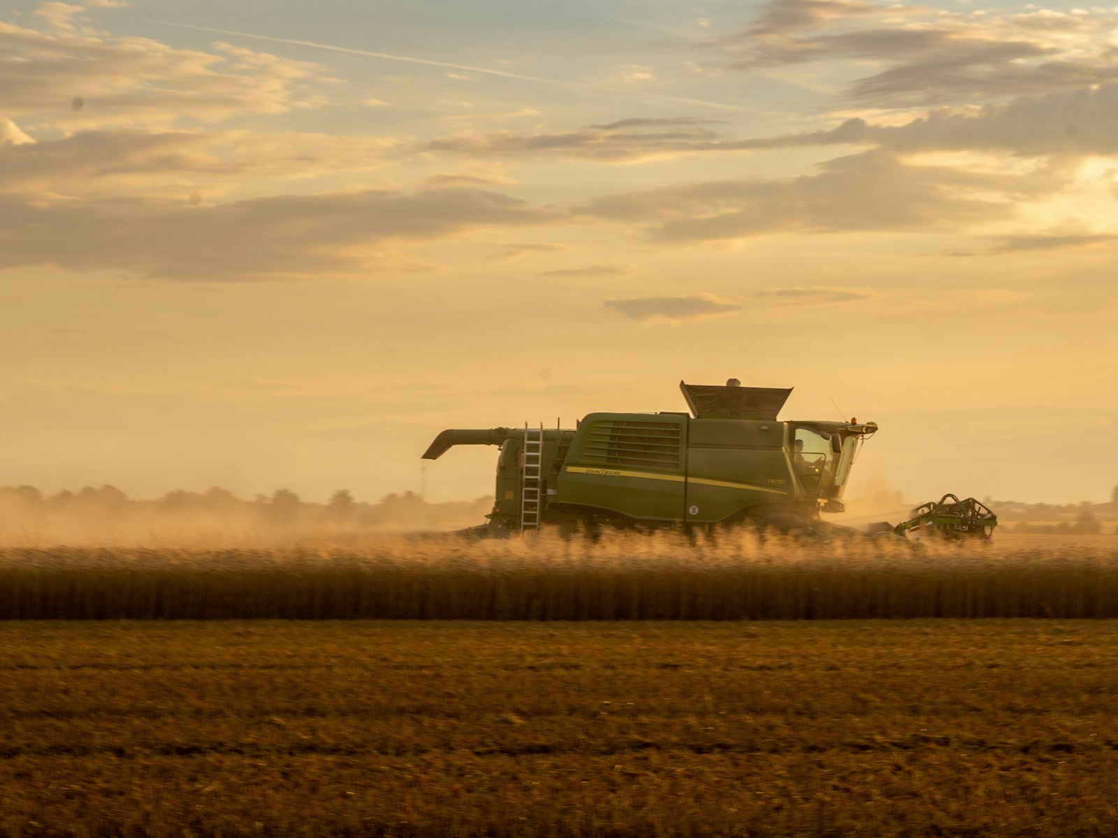 A harvester unloading grain into a chaser bin.